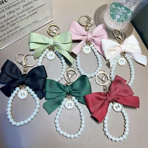 Handmade pearl bead keychain featuring a large colorful ribbon bow for bags and gifts