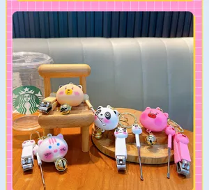 Macro view of various cartoon animal nail clippers and ear pick keychains on wooden props.