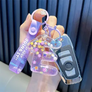 Purple liquid quicksand letter E keychain with flower sequins and silicone strap