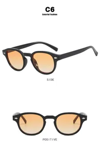 Vista detallada de gafas de sol redondas vintage con montura negra y lentes naranja degradado