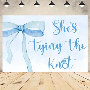 Light blue bowtie photography backdrop for bridal shower with She's tying the Knot text