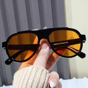 Detailed macro view of trendy black aviator sunglasses featuring vibrant orange lenses