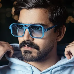 Gros plan de lunettes de soleil carrées bleues avec double pont et verres dégradés.