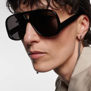 Nahaufnahme einer schwarzen, übergroßen Pilotenbrille für Damen an einem Modell mit Ohrring