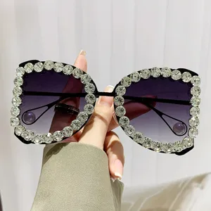 Detail van een luxe oversized zonnebril met strassrand en paarse gradiëntglazen.