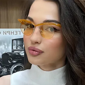 Primer plano de gafas de sol redondas de media montura para mujer con lentes ámbar retro