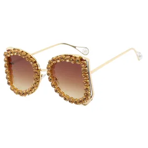 Oversized luxe zonnebril voor dames met gouden kristallen montuur en witte parels