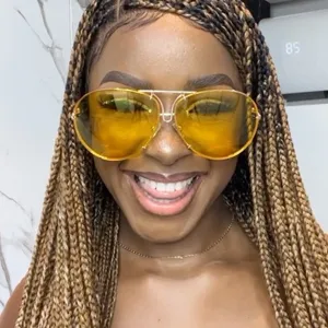 Close-up of woman wearing vintage yellow lens aviator sunglasses with metal frame