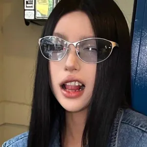 Detail view of futuristic silver metal cat-eye sunglasses on a fashion model