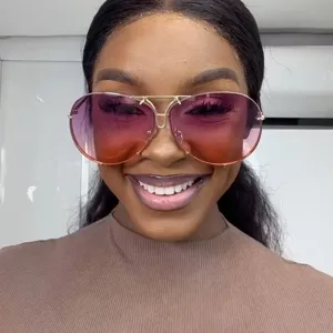 Stylish aviator sunglasses with pink gradient lenses and gold metal frame on a model