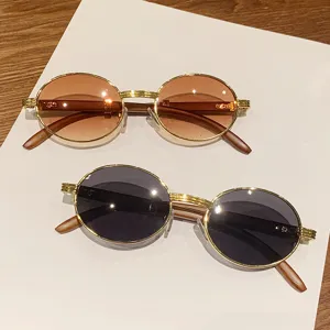 Gafas de sol ovaladas retro con montura dorada y patillas de imitación madera para mujer.