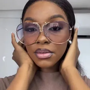 Close-up of woman wearing vintage oversized aviator sunglasses with gold metal frame