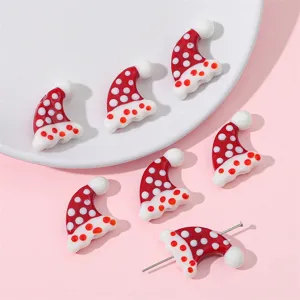 Detailed macro view of polka dot Christmas hat beads showing a needle threading through