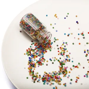 Detailed macro view of colorful 2mm glass seed beads spilling from a glass bottle