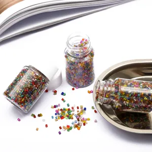 Close-up of 2mm colorful glass seed beads in small clear bottles for DIY jewelry making