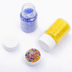 Close-up of 2mm glass seed beads in vibrant blue and yellow bottles for DIY jewelry crafting