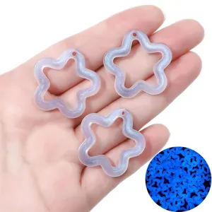 Close-up of glow-in-the-dark star pendants with fine glitter for DIY jewelry making.