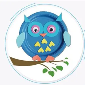 Detailed view of black and white googly eyes applied to a blue paper plate owl craft