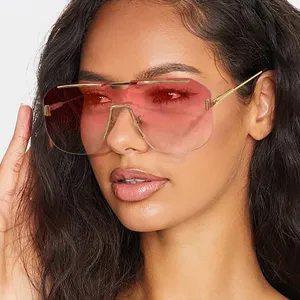 Close-up of oversized rimless square sunglasses with gradient red lenses on model