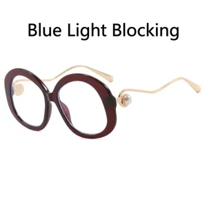 Modische runde Oversized-Brille mit eleganten goldenen Wellenbügeln und Perlen.