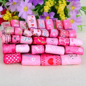 Close-up of mixed pink printed grosgrain ribbons featuring floral and heart patterns