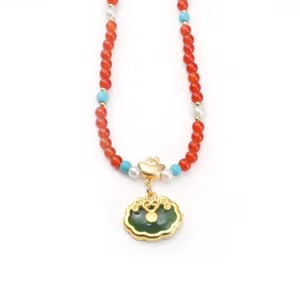 Close-up of New Chinese style Ruyi lock pendant with red and green imitation jade beads