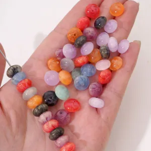 Gros plan de perles d'abaque colorées pour la fabrication de bijoux DIY sur une main