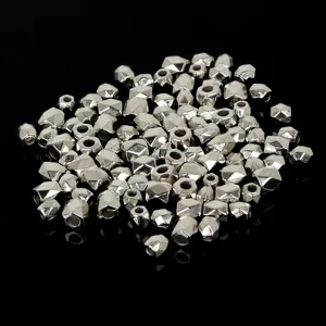 Close-up of irregular silver faceted metallic spacer beads for DIY jewelry making.