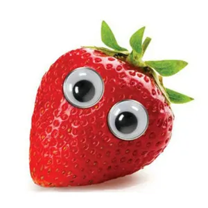 Close-up of self-adhesive googly eyes applied to a strawberry for DIY craft inspiration