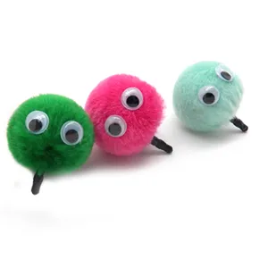 Close-up of colorful furry pom-pom dust plugs with cute googly eyes for DIY crafts