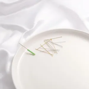 Gold and silver metal headpins for DIY jewelry making displayed on a white plate