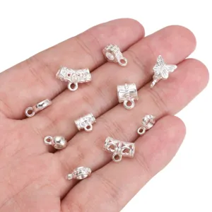 Detailed view of various silver alloy DIY jewelry spacer beads and pendants on a palm