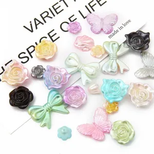 Close-up detail of various pastel gradient ABS pearl rose and bow DIY patches for hair accessories