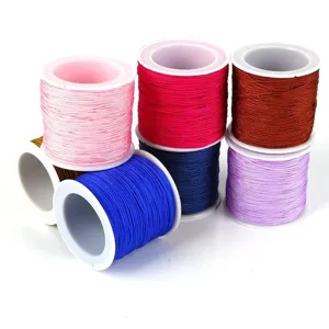Close-up of vibrant 0.8mm braided nylon jade threads in various colors on white spools