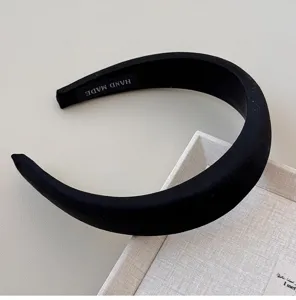 Close-up detail of a vintage black glossy wide headband featuring a luxury satin finish