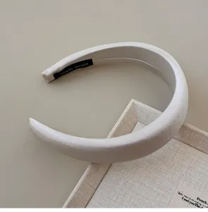 Close-up of a pearl white silky padded headband with elegant French vintage style