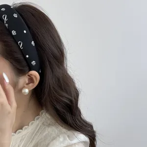 Detail shot of a minimalist black headband with white bow and floral prints on hair