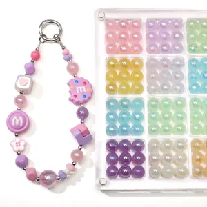 Detailed view of colorful acrylic cat eye beads and a DIY beaded phone strap