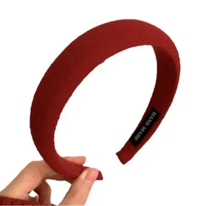 Serre-tête rembourré rouge élégant avec texture en tissu côtelé et étiquette faite main.