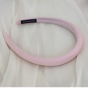 Nahaufnahme eines rosa gepolsterten Haarreifs mit einem handgefertigten Etikett