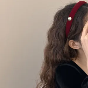 Serre-tête élégant en velours bordeaux pour femmes avec une perle pour un look volumineux.