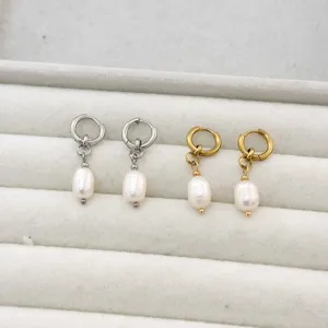 Detailed macro shot of gold and silver stainless steel hoop earrings with oval pearls