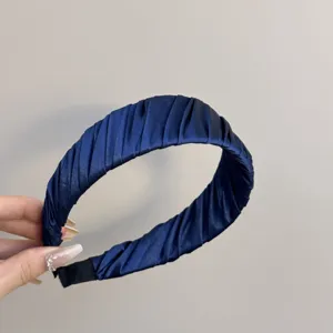 Detailansicht eines eleganten, tiefblauen, gefalteten Satin-Haarreifs für Damenmode