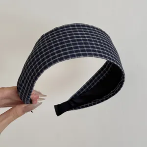 Vue détaillée d'un serre-tête large à carreaux bleus avec une texture denim