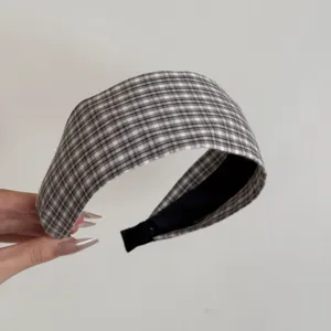 Détail d'un serre-tête large élégant avec un motif vichy gris et blanc en tissu de coton