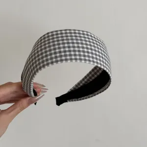 Gros plan d'un serre-tête large à carreaux noir et blanc élégant montrant la texture du tissu