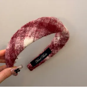 Detailed view of elegant red and white plaid wool headband with subtle gold thread accents