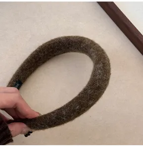 Close-up of brown plush felt headband with soft fuzzy texture for winter hair styling.
