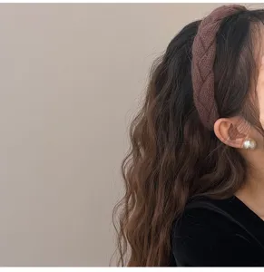 Detail van bruine gebreide gevlochten haarband voor dames, winter haaraccessoire