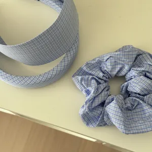 Dettaglio di cerchietto a quadretti bianchi e blu con elastico scrunchie coordinato